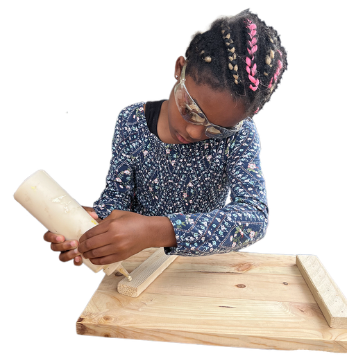 Young participant applying glue during a woodworking workshop